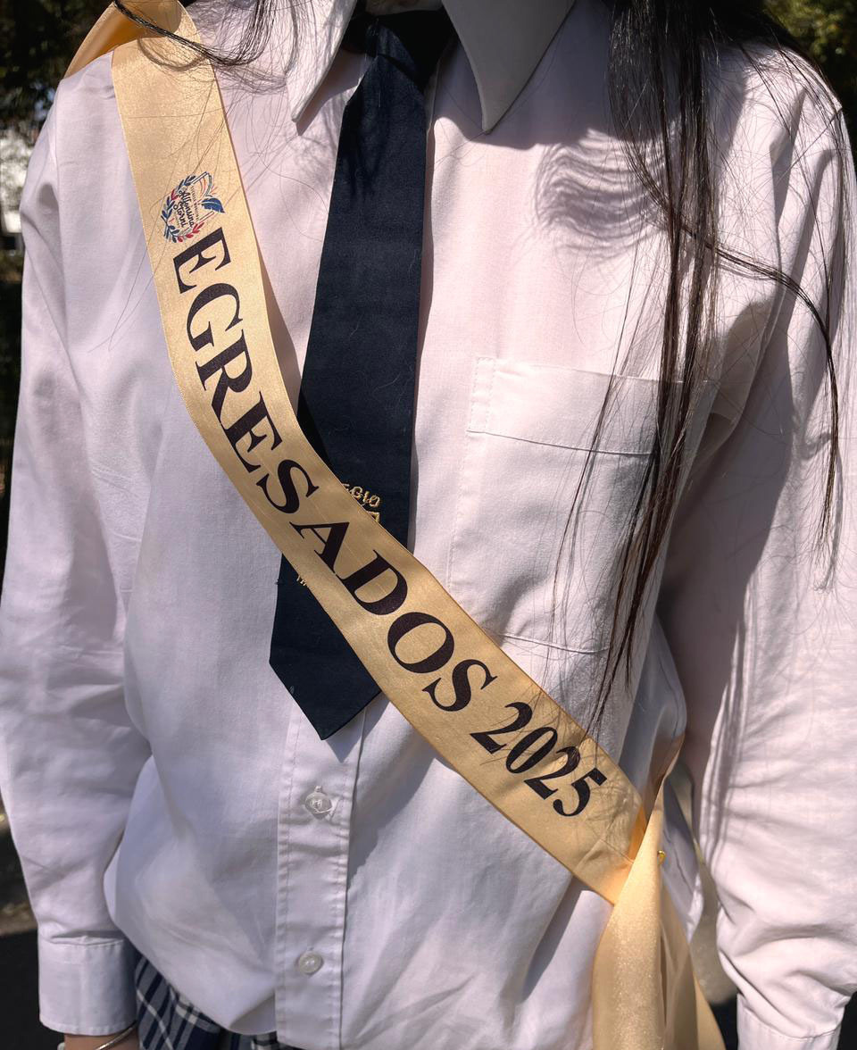 Estudiante usando una banda beige personalizada de egresados