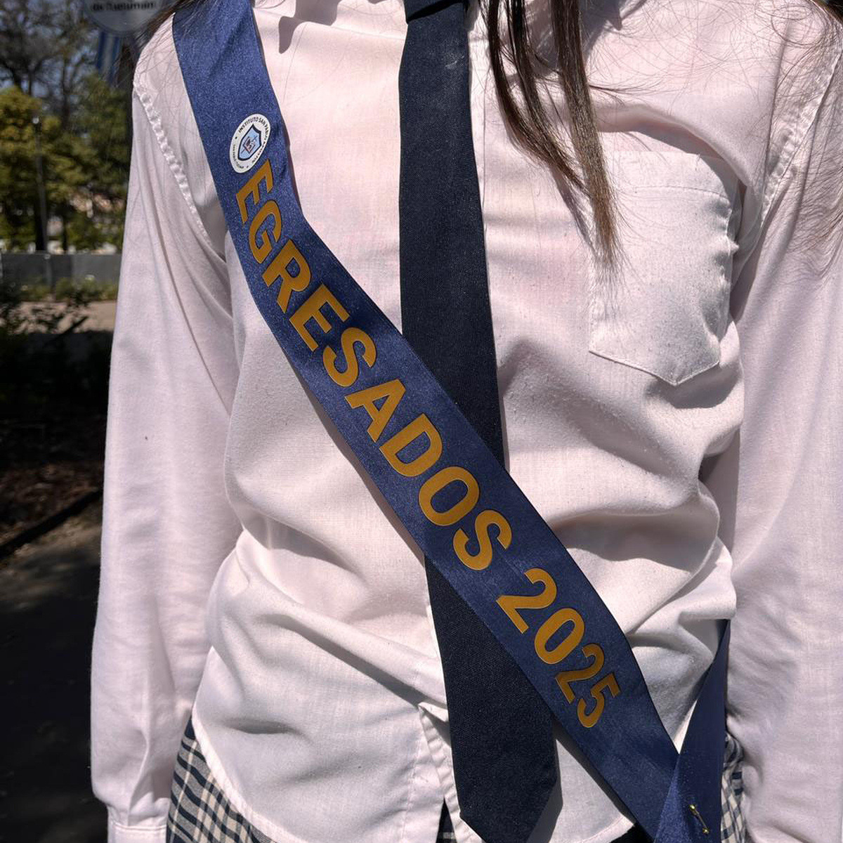 Estudiante usando una banda azul personalizada de egresados